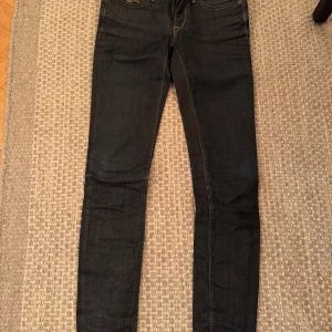 Mörkblå jeans från Replay - Snygga mörkblå jeans från Replay med klassisk femficksdesign och guldfärgade sömmar. Jeansen har en tight passform och är perfekta för en stilren look. Märkesdetalj på bakfickan. Mina favvo jeans❤️ svinsnygga!