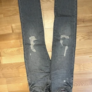 Grå jeans från Tommy Jeans - Säljer ett par grå jeans från Tommy Jeans med slitna detaljer på framsidan. De har en klassisk femficksdesign och en bekväm passform. Köpte dessa för 1599kr men säljer de för 799kr+frskt. Priset kan även diskuteras. De är även lågmidjade! 