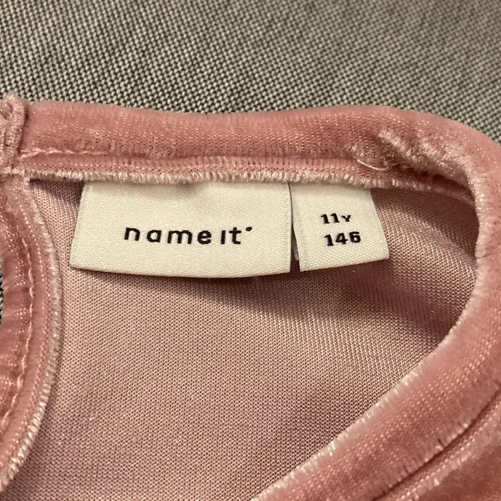 Söt rosa klänning i mjukt material från Name It. Klänningen har långa ärmar och fina volangdetaljer framtill. Perfekt för en stilfull och bekväm look.. Mekot.