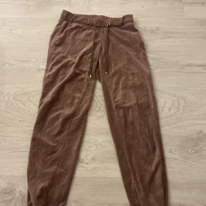 Bruna mjukisbyxor med snörning - Säljer ett par bruna mjukisbyxor i mjukt material med snörning i midjan. Perfekta för en avslappnad stil.