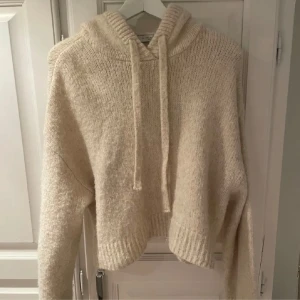 Beige stickad hoodie från Zara - Mysig beige stickad hoodie från Zara med en avslappnad passform. Tröjan har en stor huva med dragsko och långa ärmar. Perfekt för kyliga dagar! Passsr storlek S 