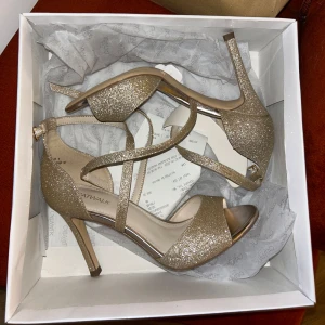 Glittriga guldiga klackskor från Catwalk - Snygga glittriga klackskor i guld från Catwalk. Använda endast en gång på balen!