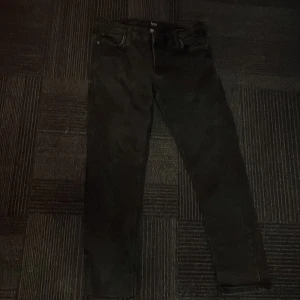 Svarta jeansbyxor - Snygga svarta jeansbyxor med en klassisk femficksdesign. De har en dragkedja och knapp framtill. Perfekta för en stilren look.W33 L30