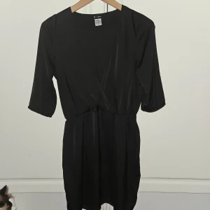 La Redoute svart klänning/tunika storlek 36 - Nyskick Svart klänning/tunika med v-ringning och 3/4 ärmar. Klänningen har en elastisk midja och är gjord av ett mjukt, lätt material. Tyvärr är lappen bortklippt men det är 30° Märket la redoute