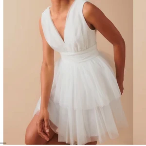 Vit volangklänning - Gullig vit klänning med v-ringad hals och volangdetaljer. Perfekt för student eller skolavslutning mm. Klänningen finns ej att köpa online. Nypris 600kr, storlek XS, oanvänd med lappar💕