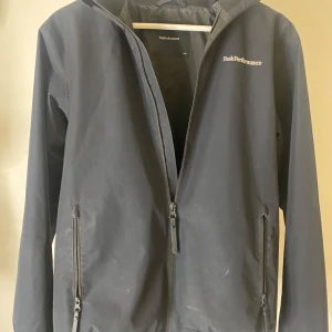 Svart jacka från Peak Performance - Snygg svart vind jacka från Peak Performance med dragkedja och hög krage. Perfekt till våren. Storlek 170