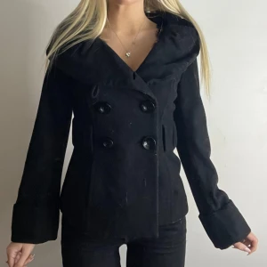 Svart figursydd kappa  - Super snygg figursydd kappa i bra skick! Stork S. Tryck köp nu! 💌