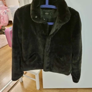 Svart pälsjacka från Only - Snygg och mysig svart pälsjacka från Only. Jackan har långa ärmar och en klassisk krage. Strl xs