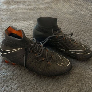 Nike hypervenom phantom 3 elite - Säljer ett par svarta Nike fotbollsskor med orange detaljer. Skorna är sällsynta och svåra att få tag på. Finns litet slitage på höger sko (sista bilden) annars väldigt fint skick. Köpta för 3000. 