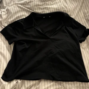 Svart kortärmad blus - Snygg svart blus med korta ärmar och en klassisk krage. Perfekt för en stilren look.