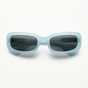 Ljusblå solglasögon från Sun Buddies - Aldrig använda semi transparenta 70-talsinspirerade solglasögon med fyrkantig ram i ljusblå ton, handgjord av Italienskt acetat. Grå Carl Zeiss-linser med 100% UV-skydd och ett sjustavgångsjärn med två synliga nitar på tinningen. Kommer i ett hårt fodral i konstläder. Originalpris 1600kr.