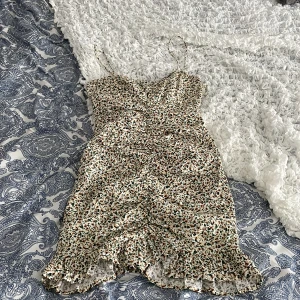 Blommig klänning från Zara - Söt blommig klänning från Zara med smala axelband och volangdetaljer. Klänningen har en figurnära passform. Den har ett vackert mönster i grönt och brunt på en ljus bakgrund. Säljer pågrund av att den har blivit för liten. Och har inge hål elr sånt(som jag upptäckt iallafall)❤️