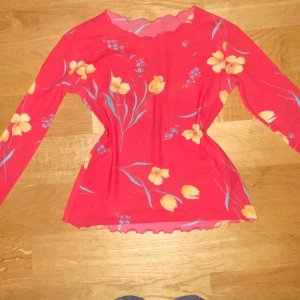 Cool röd see through tröja med tulpaner - En jättecool tröja som är röd och har tulpaner på sig.  Den är lite see through som man kan see på sista bilden. Finns tyvärr varken märke eller storlek på tröjan då det inte finns någon lapp. Skulle gissa på S men kontakta mig för mer info☺️☺️ 