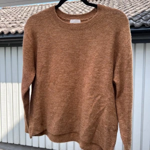 Brun stickad tröja - En ljusbrun stickad tröja från H&M. Säljer pga att den bara kom till användning ca 3 gånger. Sann till storleken 🤎  Längd: 55 cm Axel: 48 cm Byst: 110 cm