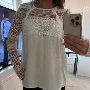 Blus med spets  - Säljer denna vackra vita blus med långa ärmar och spetsdetaljer i storlek S. Perfekt för vardag och speciella tillfällen!