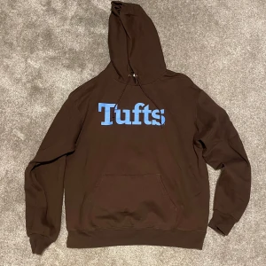 Vintage Champion hoodie - Säljer en brun hoodie från Champion med ljusblått Tufts-tryck på framsidan. Köpt second hand men mycket bra skick. Storlek L. Skriv vid frågor eller för fler bilder
