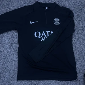 PSG x Nike half zip tracksuit  - Snygg svart långärmad tröja från Nike med PSG logga och Qatar Airways tryck. Byxor finns med om önskas men extra dyrt, kontakta mig för mer bilder. Priset kan diskuteras vid snabb affär. 