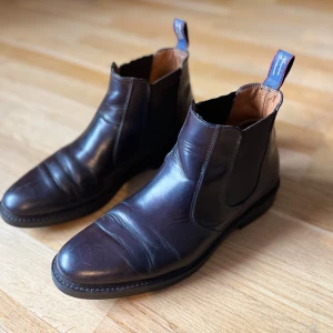 Bruna Chelsea boots i skinn från Gant - Snygga bruna Chelsea boots i skinn från Gant med elastiska paneler på sidorna för enkel på- och avtagning. De har en klassisk design med dragflikar baktill och en robust sula. Tillverkade i Italien 