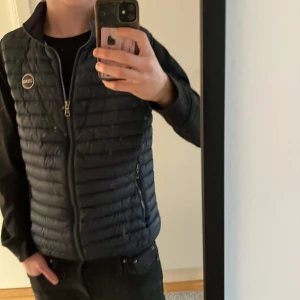 Navy väst från Colmar - Säljer en snygg mörkblå väst från Colmar. Jackan har en dragkedja framtill och en stilren design med ett märke på bröstet. Perfekt för vår och höst. Storlek är 16 y som motsvarar xs/s i herr. Priset kan diskuteras 