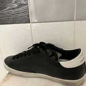 Svarta sneakers från Golden Goose - Snygga svarta sneakers från Golden Goose med vit stjärndetalj på sidan.