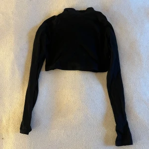 Svart croppad polotröja - Snygg svart croppad polotröja med långa ärmar. 