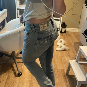 Blå jeans från True Religion - Jätte snygga blå jeans från True Religion i stolek 26. Har sytt upp dem då dem egentligen är onesize i längden. Är ungefär 160 och därför skulle jag säga att dem passar dem som är 160-165. Har använt dem max 2 gånger❤️❤️