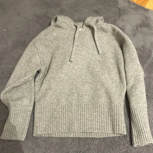 Grå hoodie från Zara - Mysig grå hoodie från Zara i mjukt material. Tröjan har en klassisk design med huva och dragsko samt ribbade muddar vid ärmslut och nederkant. Perfekt för kyliga dagar.