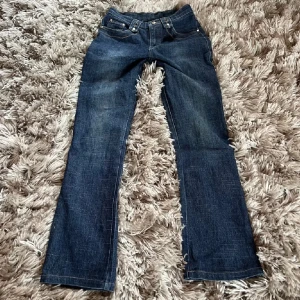 Blå bootcut jeans - Snygga blå bootcut jeans med klassisk femficksdesign och knappar.  Köpta på plick. Midjamått: 33 cm rakt över. innebenslängd: 75cm