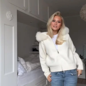 Vit stickad jacka med huva - Mysig vit stickad jacka med dragkedja och fluffig huva. Perfekt för kyliga dagar med sin ribbade nederkant och långa ärmar. Jätte populär tröja som ser ut som den från Alessa som kostar 2200kr. Helt ny och passar nog fler storlekar.