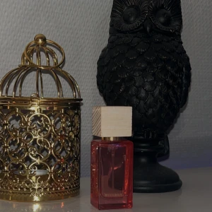 Rituals Rêve de Hanami Eau de Parfum - Säljer en elegant parfym från Rituals, Rêve de Hanami, i en stilren flaska med rödtonat glas och trälock. Perfekt för den som älskar en sofistikerad doftupplevelse. Flaskan rymmer 15 ml. Endast testad. 