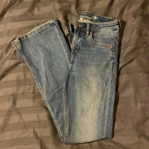 Blå jeans  - Snygga blå jeans med en klassisk femficksdesign. Jeansen har en lätt tvättad look och raka ben. Perfekta för en avslappnad stil.