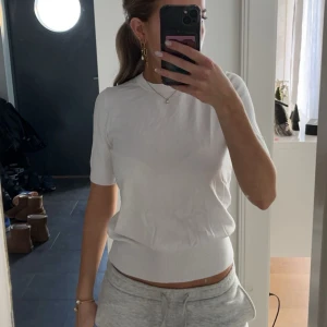 Vit kortärmad topp - Säljer en stilren vit topp med korta ärmar och en mudd längst ner. Köpt på zara.