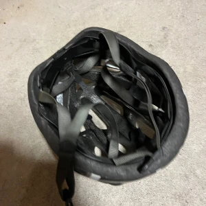 Cykelhjälm från Giro - Snygg och aerodynamisk cykelhjälm från Giro i svart och grått. Hjälmen har flera ventilationshål för optimal luftcirkulation och justerbara remmar för perfekt passform. Perfekt för cykling i alla väder. Det är bra för att åka långa distanser för att den har många håll i sig som gör att det inte blir så varmt i den. Den skyddar utmärkt den har kanske några skrapor men den är små och man kommer inte märka de så bra