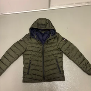 Napapijri dunjacka - Napapijri jacka i en snygg grön färg! Jackan har knappt någon defekt och är nästintill ny skick. Jackan är köpt för 2199 och säljs för 1199! Jackan är i storlek S och passar om man är ungefär 173-185. Om du har några fler frågor är det bara att skriva!