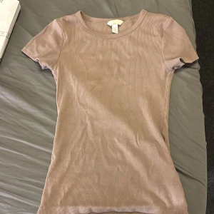 Beige/brunribbad t-shirt - Säljer en stilren beige ribbad t-shirt med korta ärmar. Knappt använd .