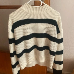 Randig stickad tröja från Shein - Säljer en snygg stickad tröja från Shein i krämvitt och svart. Tröjan har ett randigt mönster och långa ärmar. Storleken är L men sitter som s.
