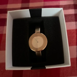 Söt klocka från Calvin Klein - Snygg och stilren klocka från Calvin Klein med en minimalistisk design. Klockan har en rund urtavla i silver och ett matchande armband. Aldrig använd förutom att testa den. Var menad som present men var lite för stor så blir att sälja den här istället, hör av dig vid minsta fundering