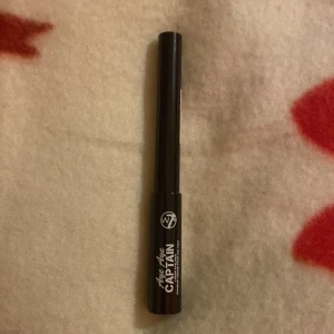 Flytande eyeliner från W7 - Snygg flytande eyeliner från W7 med namnet 'Like the Captain'. Perfekt för att skapa skarpa och definierade linjer. Produkten är vegansk och cruelty-free, vilket gör den till ett bra val för djurvänner. Kommer i en smidig svart förpackning. INTE ANVÄND!!
