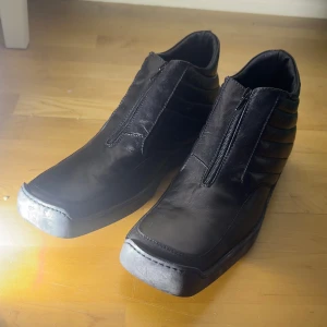 Svarta boots från Charles Jourdan - Snygga svarta boots i skinn från Charles Jourdan med dragkedja framtill. Skorna har en quiltad design på sidorna och en robust sula. Perfekta för en stilren look. Gjorda i Italien och har från början listad 2450kr