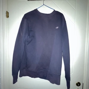 Mörkblå sweatshirt från GANT - Säljer en stilren mörkblå sweatshirt från GANT med liten logga på bröstet. Tröjan har långa ärmar och rund halsringning, perfekt för en avslappnad look. Passar bra till både jeans och chinos.