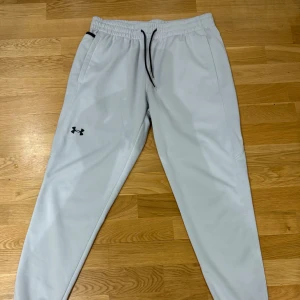 Grå Under Armour träningsbyxor  -  Säljer ett par ljusgrå Under Armour-byxor i perfekt skick – inga tecken på användning och av högsta kvalitet. Materialet är både bekvämt och slitstarkt, vilket gör dem perfekta för träning, vardagsbruk eller avslappnade dagar hemma.  ✔️ Märke: Under Armour ✔️ Färg: Ljusgrå ✔️ Skick: Som nya, utan slitage ✔️ Storlek: L  Pris kan diskuteras 