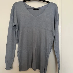 Blå tröja från Mango - Stilren blå tröja från Mango. En v-ringad hals och långa ärmar. Den är tillverkad i ett mjukt material som känns skönt mot huden. 🩵🩵
