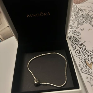 Silverarmband från Pandora - Elegant silverarmband från Pandora med en klassisk design. Perfekt för att lägga till berlocker och skapa en personlig stil. Levereras i originalförpackning.     