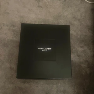 Svarta sneakers med stjärndetaljer från Saint Laurent - Snygga svarta sneakers från Saint Laurent med glittriga detaljer och vita stjärnor på sidorna. Dom är 38 or men en lite större så passar även 39