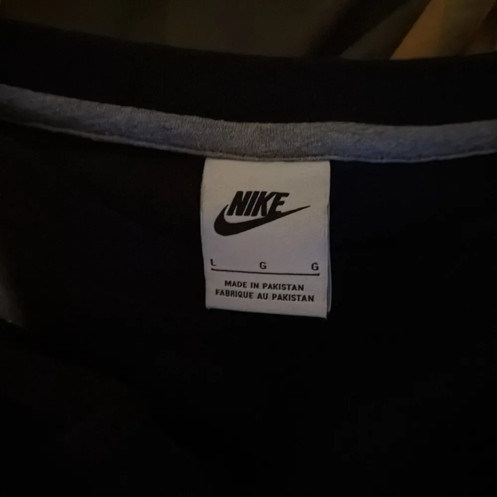 Säljer en stilren svart tröja från Nike med deras ikoniska logga på bröstet. Tröjan har en klassisk passform och är perfekt för en avslappnad look. Tillverkad i ett mjukt material för extra komfort.. Neuletakit & Villapaidat.