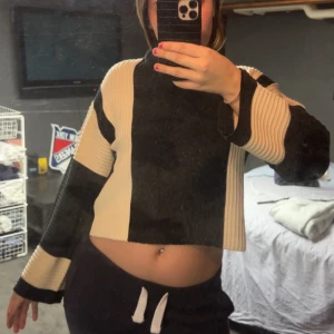 Svart och beige croppad tröja - Säljer en svart och beige croppad tröja med långa ärmar. Tröjan har ett unikt blockmönster och är perfekt för en trendig look. Passar bra till både jeans och kjol. Tröjan har prislappen kvar då den aldrig är använd 