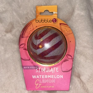 Bath Fizzer Watermelon & Lemon - En färgglad badbomb från Bubble T med doft av vattenmelon och citron. Perfekt för att skapa en avkopplande och uppfriskande badupplevelse. Den har en randig design i rött och gult och väger 150g.