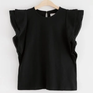 Volang topp - En svart topp med volanger på ärmarna, tyget är inte tunt. Säljer då den var lite stor i storleken