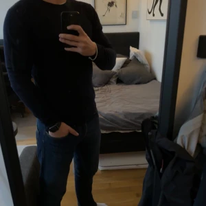 Marinblå tröja från J.Lindeberg - Säljer en stilren marinblå tröja från J.Lindeberg. Tröjan har en klassisk design med rund hals och långa ärmar. Perfekt för en minimalistisk look. Tröjan är i marinoull.