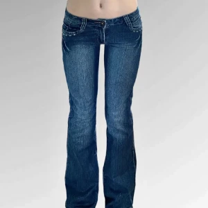 Blå bootcut jeans lågmidja - Snygga blå bootcut jeans från ONADO med broderade detaljer på bakfickorna. De har en lågmidjad passform. Midja 35,5 längd 102 och innerben 82cm. Köp gärna💕